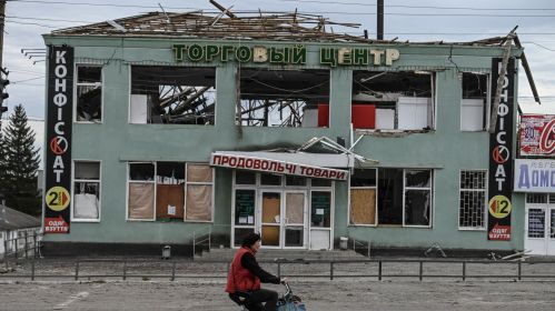 Здымак мае ілюстрацыйны характар. Жанчына едзе на ровары міма разбуранага будынку ў Балаклеі, Харкаўская вобласць, Украіна. 10 верасня 2022 года. (Фота: Juan Barreto / AFP / East News)