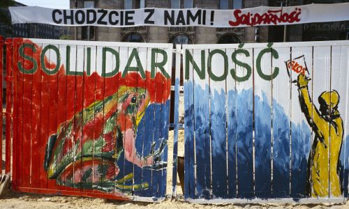 Ogrodzenie metra w Warszawie, budowanego w PRL przez wiele lat, a w maju 1989 roku  ozdobionego rysunkami popierającymi kandydatów Solidarności do tzw. sejmu kontraktowego. Fot. Bernard Bisson / Sygma via Getty Images