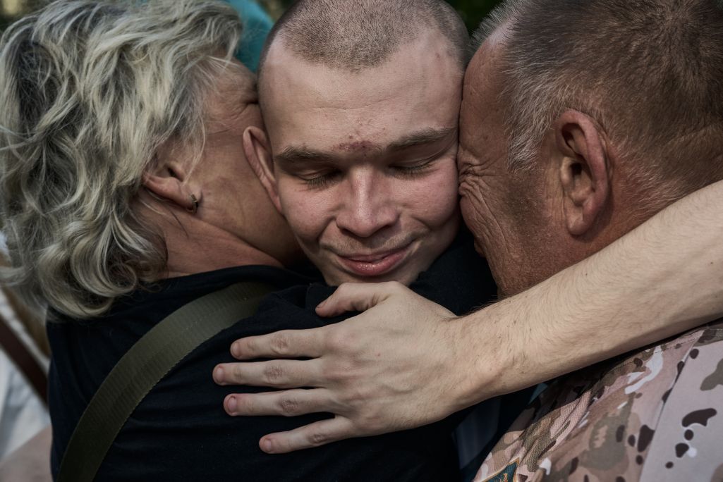 Украінскі ваеннапалонны абдымае сваякоў пасля абмену паміж Украінай і Расеяй у Чарнігаўскай вобласці. Гэта быў 57-ы абмен палоннымі з пачатку поўнамаштабнага ўварвання Расеі ва Украіну. Дзякуючы працы каардынацыйнага штабу з расейскага палону вярнулі яшчэ 103 вайскоўцаў. Чарнігаўская вобласць, Украіна. 14 верасня 2024 года. Фота: Kostiantyn Liberov / Libkos / Getty Images