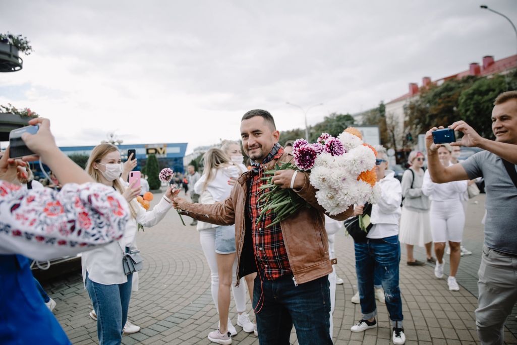 Сцяпан Латыпаў раздае кветкі дзяўчатам, якія стаяць у ланцугу салідарнасці. Менск, Беларусь. 12 жніўня 2020 года. (Фота: VS / Facebook)