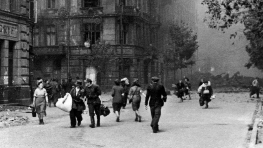 Płonąca ulica Jasna podczas Powstania Warszawskiego. Po lewej widoczny fragment gmachu Filharmonii Narodowej. Fotografia pochodzi z serii pocztówek, wydanych przez autora własnym sumptem ok. 1945. Fot. reprodukcja: Janusz. Fila / RSW / Forum
